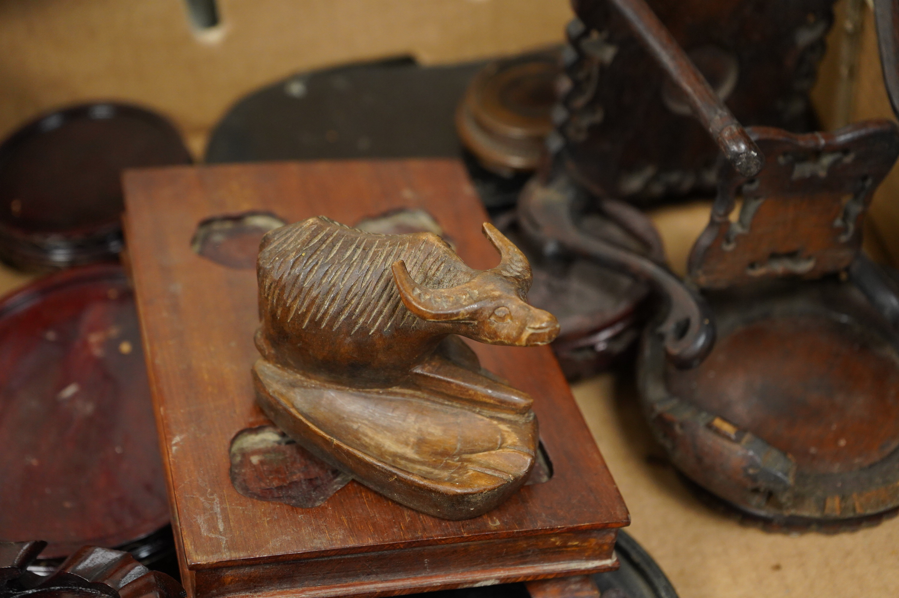 A collection of various Chinese stands, a carving of an ox and another
